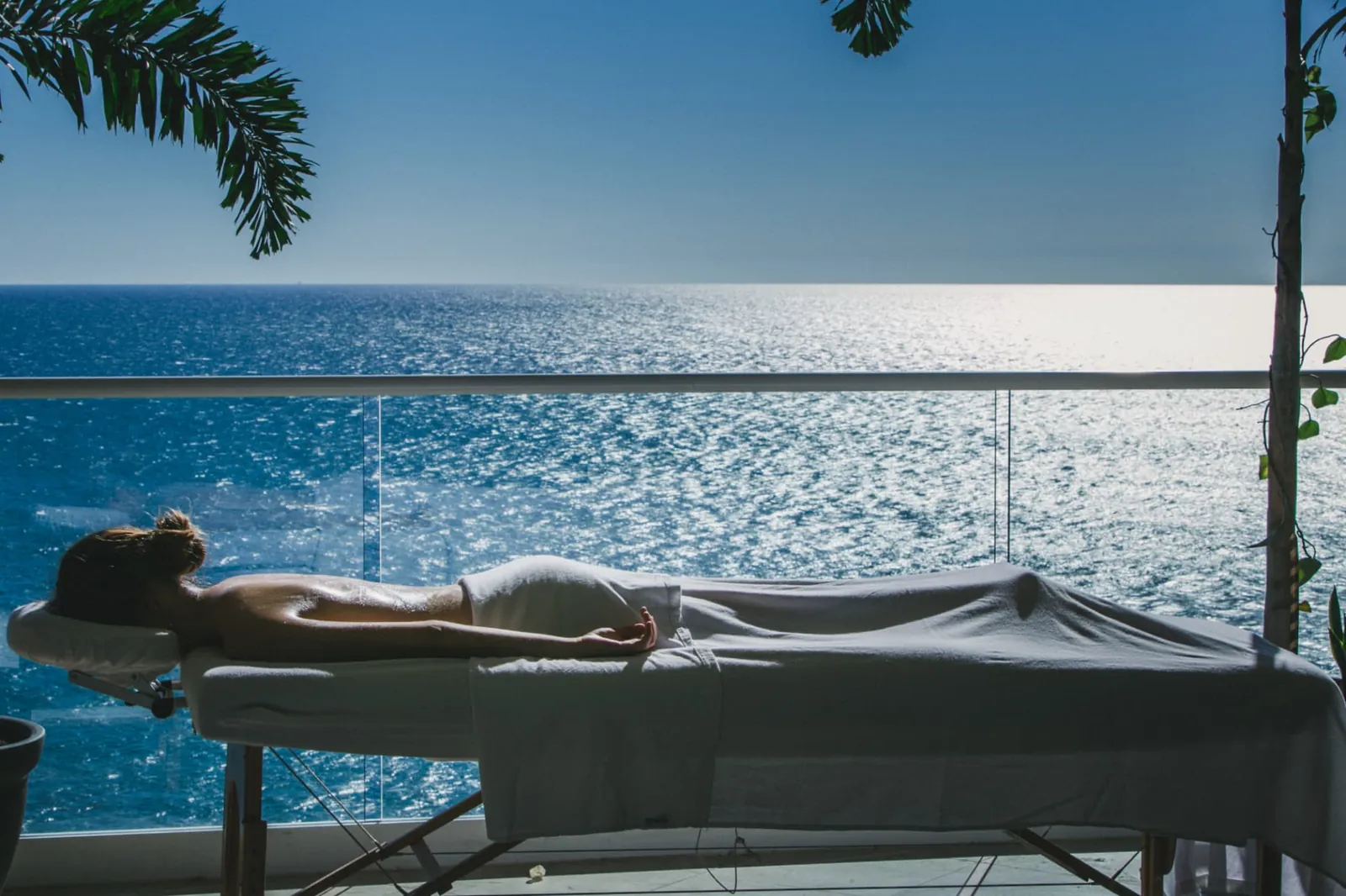 Guest resting on a massage table on a terrace facing the open Pacific