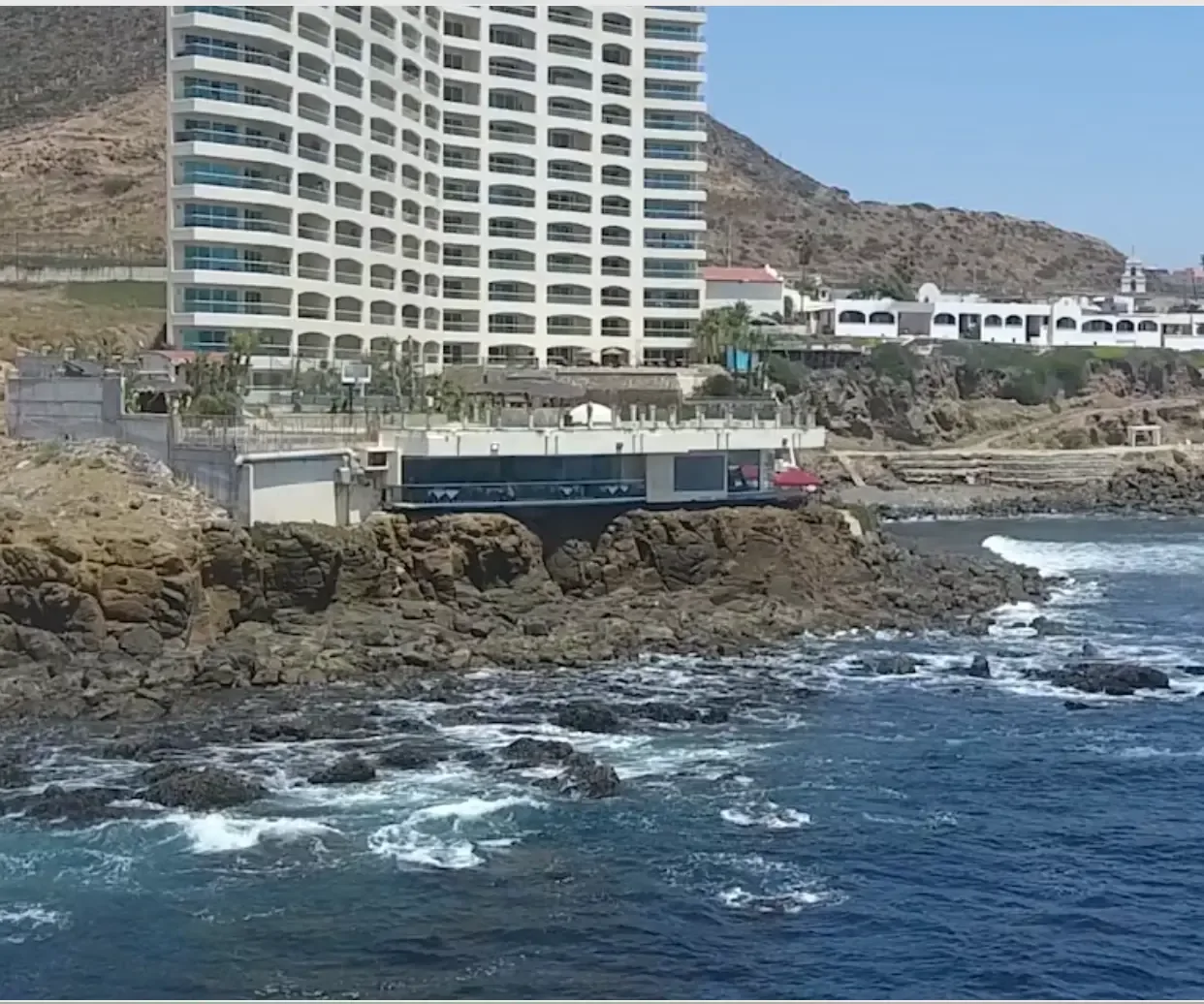 Drone view of the Holistic Sanctuary building on the rocky Pacific shoreline