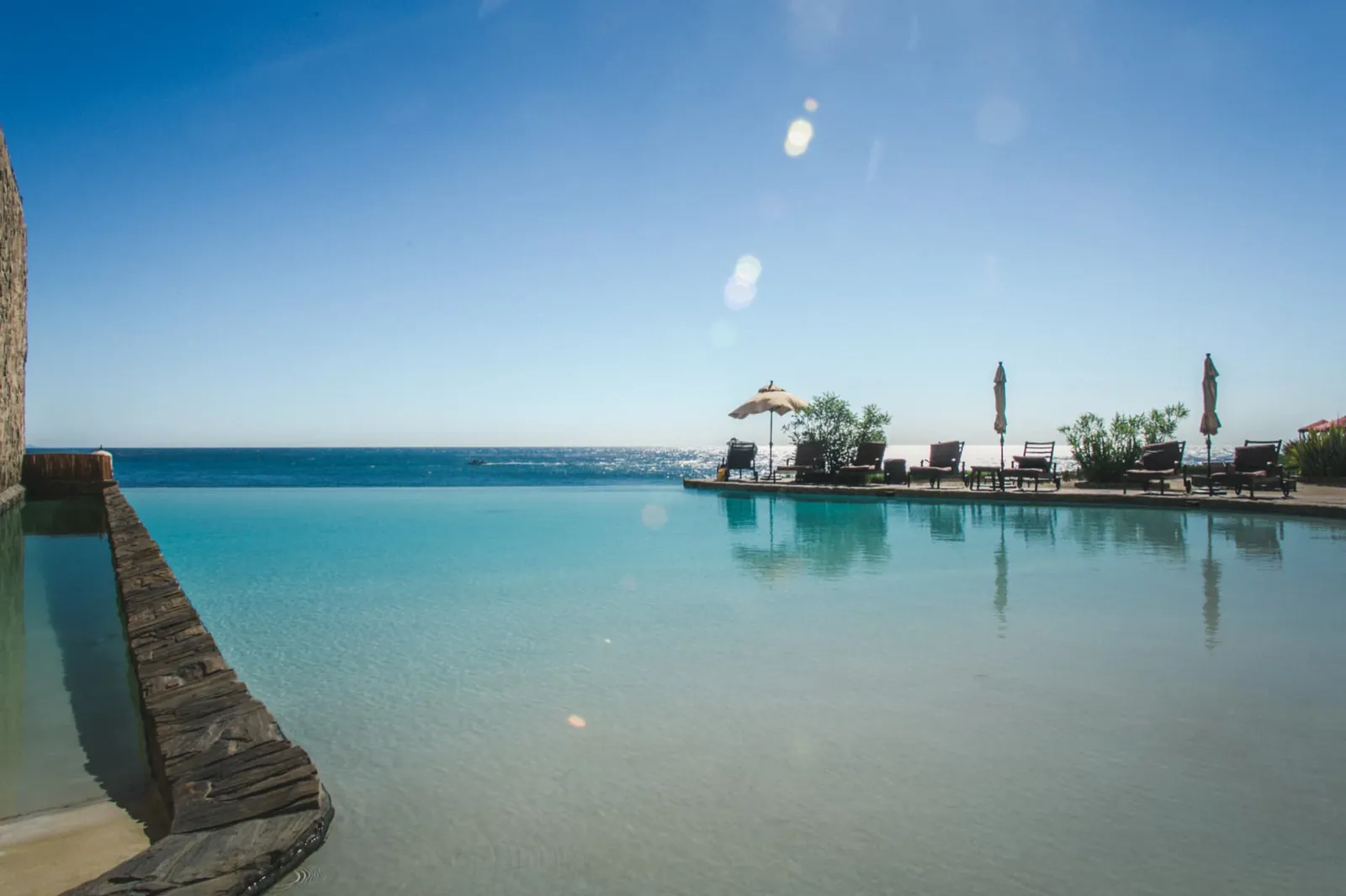 Infinity pool at Holistic Sanctuary meeting the horizon of the Pacific Ocean