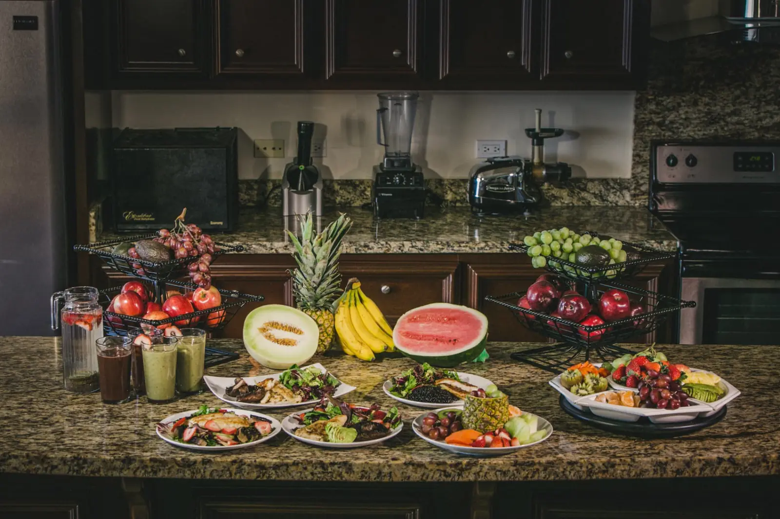 Kitchen counter laid out with organic fruit, salads, juices and smoothies at Holistic Sanctuary